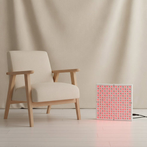 Napio Glow Red Light Therapy Panel beside linen armchair in minimal room